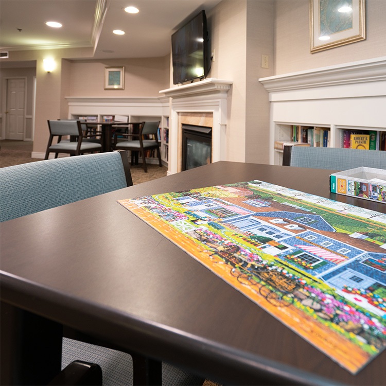 table with a colorful puzzle spread out on it, accompanied by a single chair nearby.