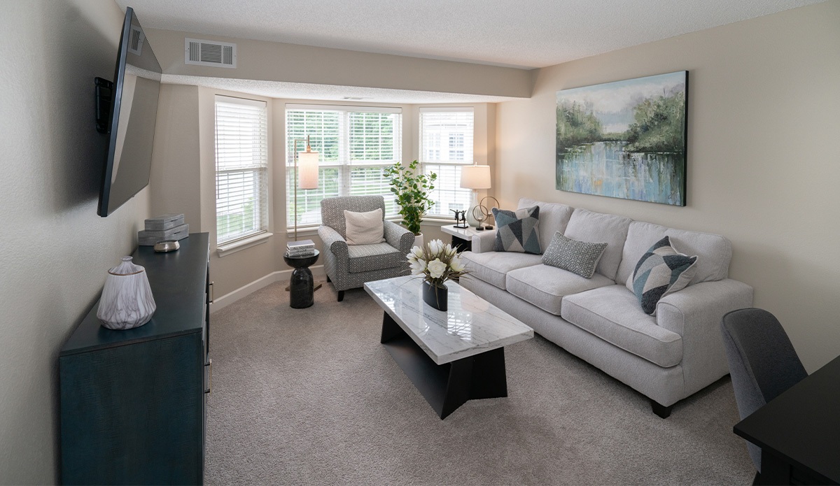 living room featuring a couch, coffee table, and a flat-screen TV on the wall.